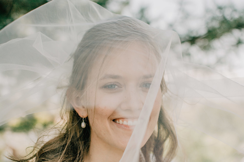 Bride smiling with veil over eyes at Logan LDS temple