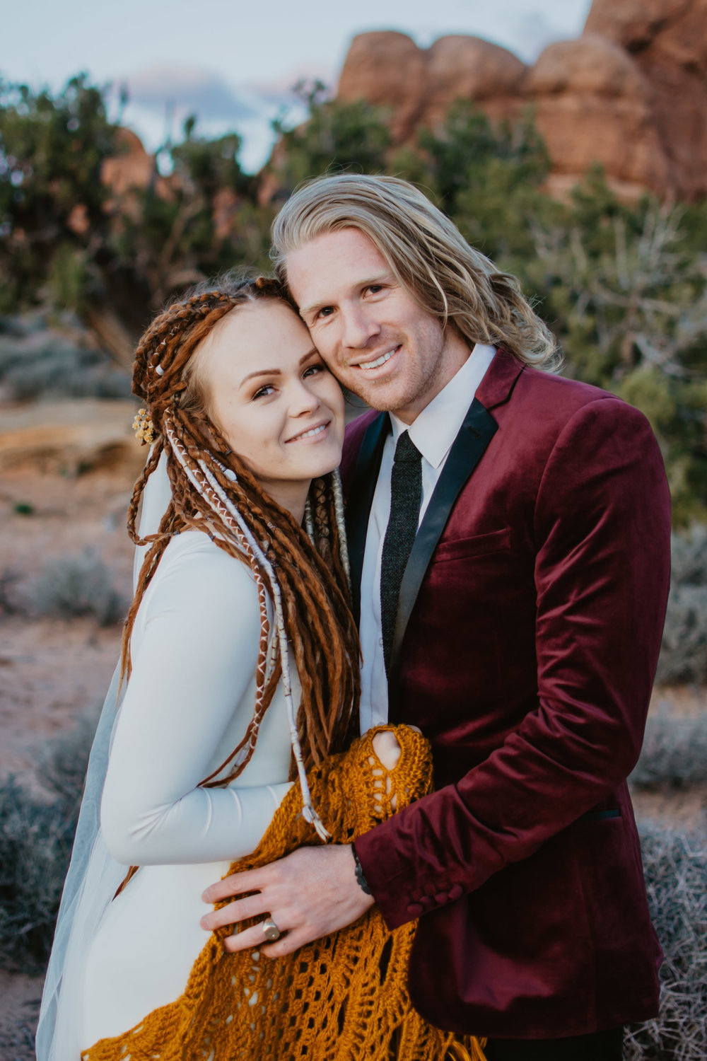 Jocilyn Bennett Photography | Destination Wedding Photographer | Elopement Wedding Photographer | National Park Elopement Photography | Capturing raw and genuine emotion | Utah Photographer | Utah wedding Photographer| National Park Weddings | Adventure Photographer | Bohemian photography | Bohemian wedding | Arches wedding | Arches National Park | Bride with dreads | Candid Bridal Photos | handmade bridal gown | ASOS red suit coat | yellow knitted cover for dress |