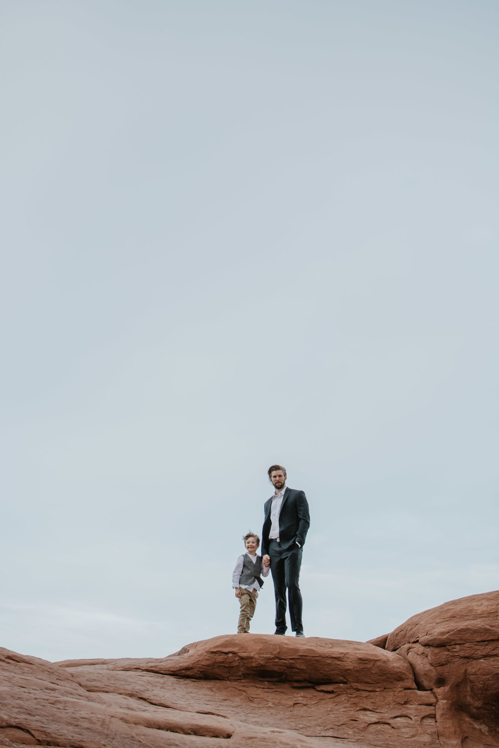 Jocilyn Bennett Photography | Family photo session | Family picture pose ideas | Family portraits | Portrait Photography | Capturing raw and genuine emotion | Utah Photographer | Idaho Photographer | Adventure Photographer | Candid Photography | Candid family poses | Family pictures outfit ideas | Color ideas for family photos | Arches National Park | Family pictures at Arches National Park | Little boy at Aches | Father-son Photos |