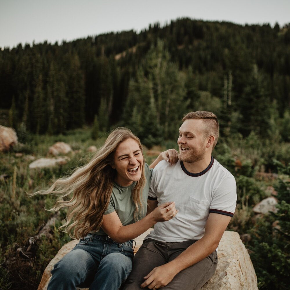 mountain summer session with woman and man laughing in a wildflower field