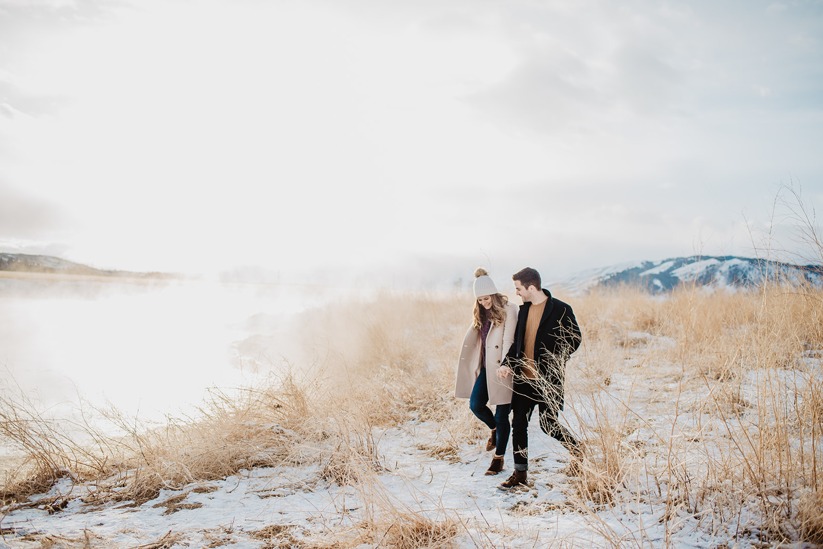 mana nd woman walking by a lake in Jackson Hole during their winter engagement session