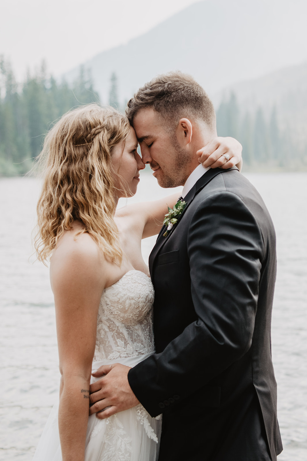 bride and groom embracing as they stand in the river at the Tetons for their wedding while they include your dog in your Grand Teton wedding