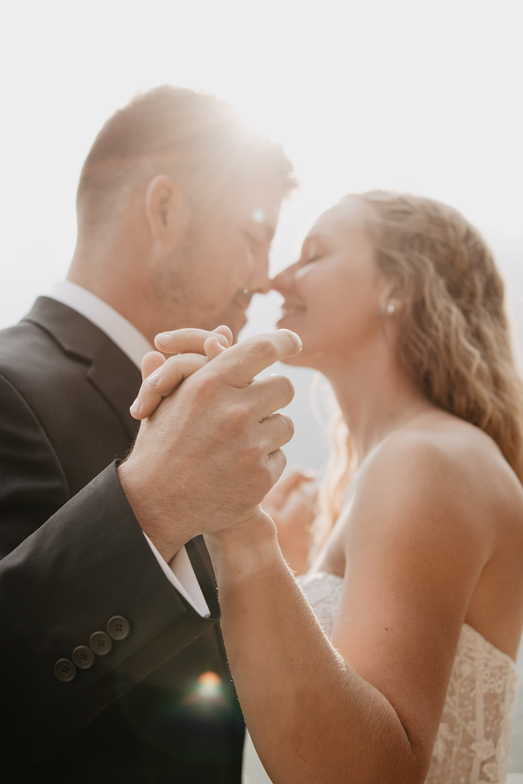 plan your elopement in 6 months with JAckson Hole wedding photographer, image of bride and groom holding hands and touching their noses together as the sun beams behind them
