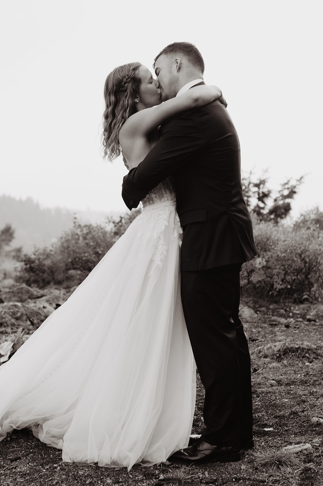 black and white image of couple kissing on their wedding day at Jackson Hole's wedding tree for their ceremony and first kiss as husband and wife