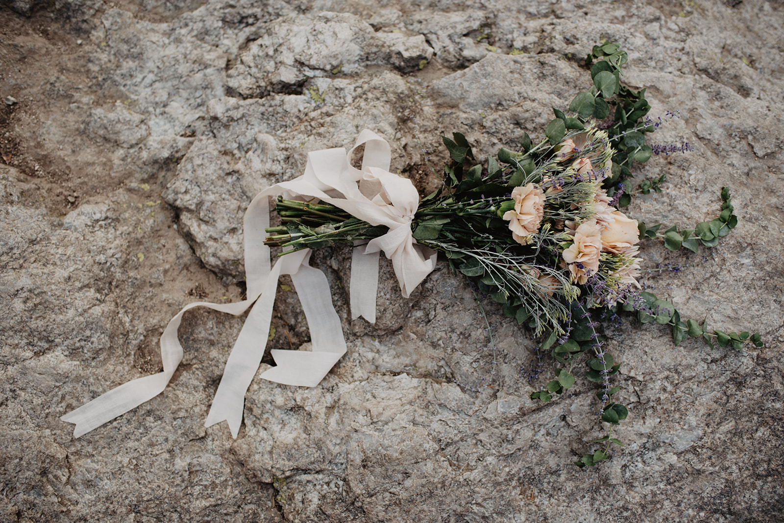 wildflower wedding bouquet that has a wild and free style laying on a rock in the Grand Tetons