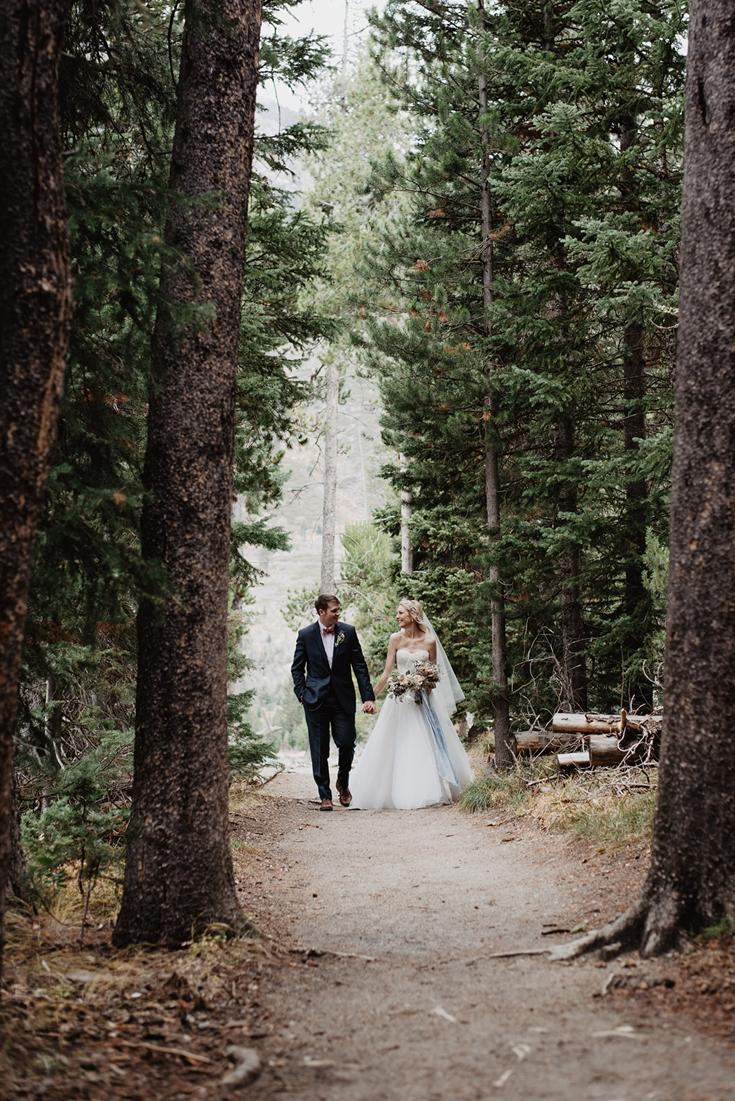 bride and groom hiking through the woods in Jackson Hole for their adventure wedding session with best JAckson Hole wedding photographer