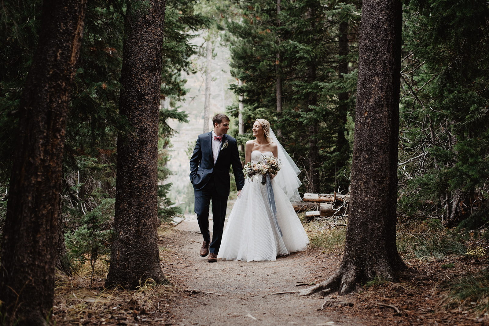 Bentwood Inn weddings with bride and groom walking through the woods in Jackson Hole on their Grand Teton wedding day for an adventure session with Jackson Hole best wedding photographers 