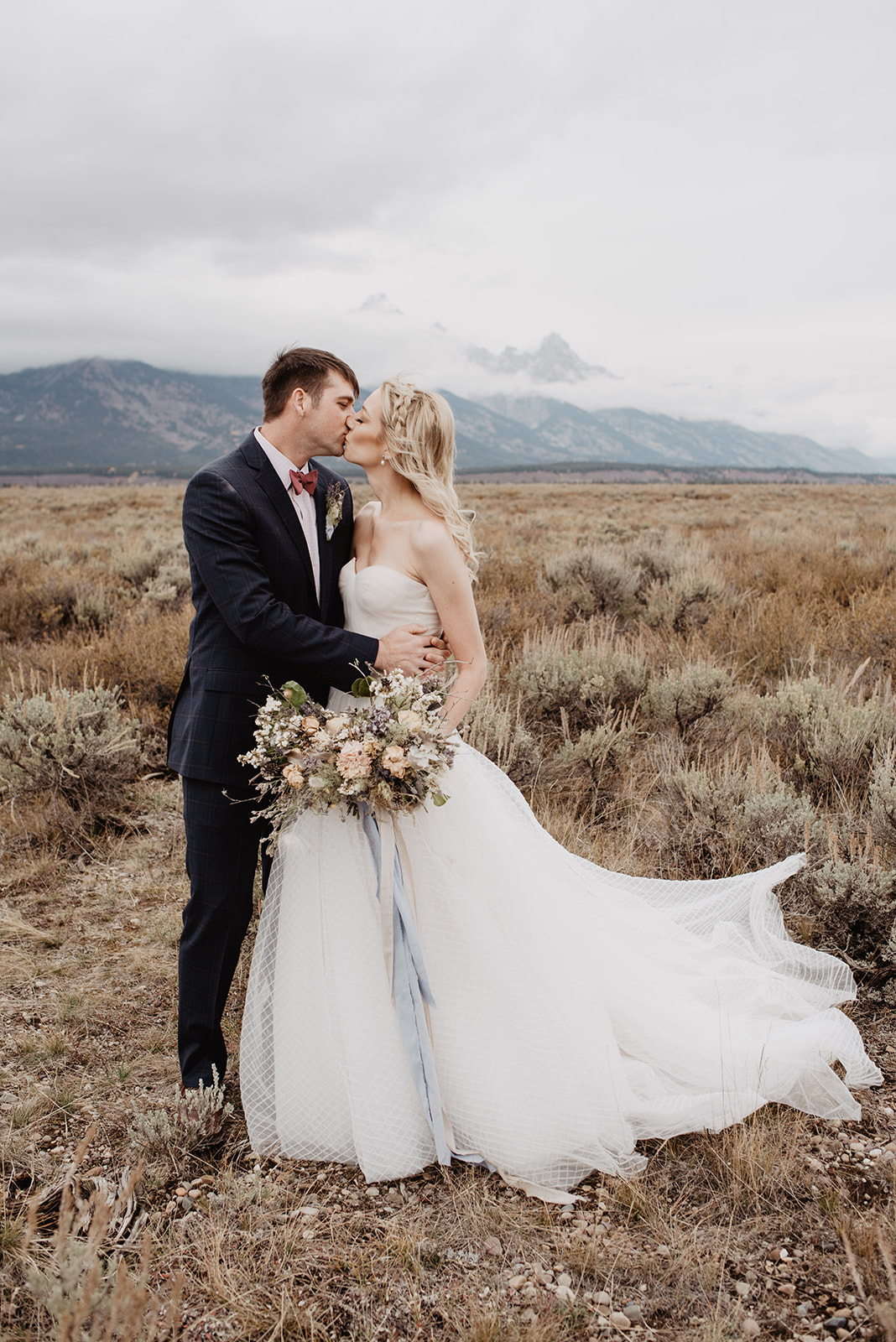 stormy wedding day in the Grand Tetons with bride and groom holding each other close and kissing for their fall bridals in JAckson Hole, captured by favorite JAckson Hole wedding photographer
