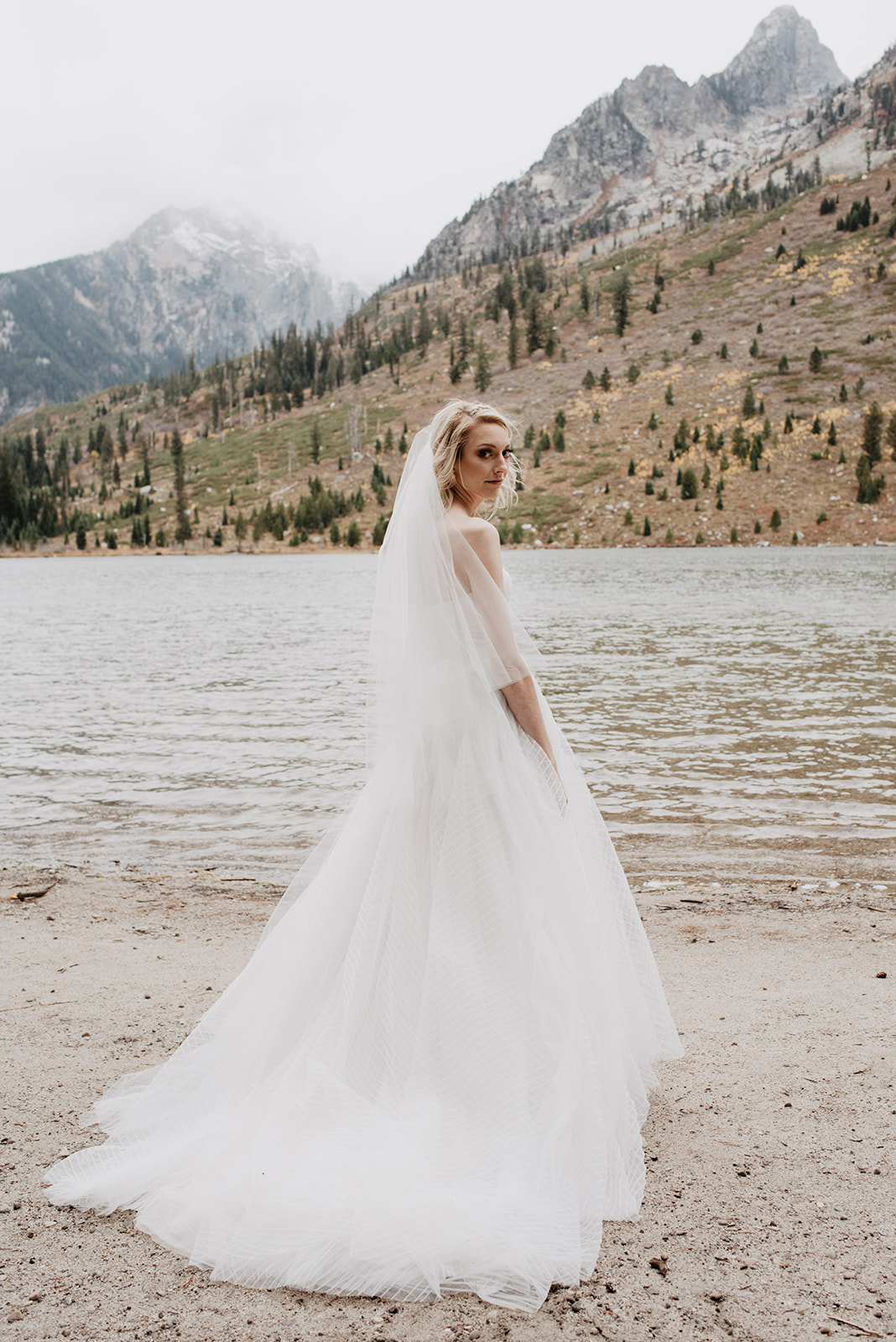 bride standing on the shore of String Lake next to the Tetons in Jackson Hole WY weddings