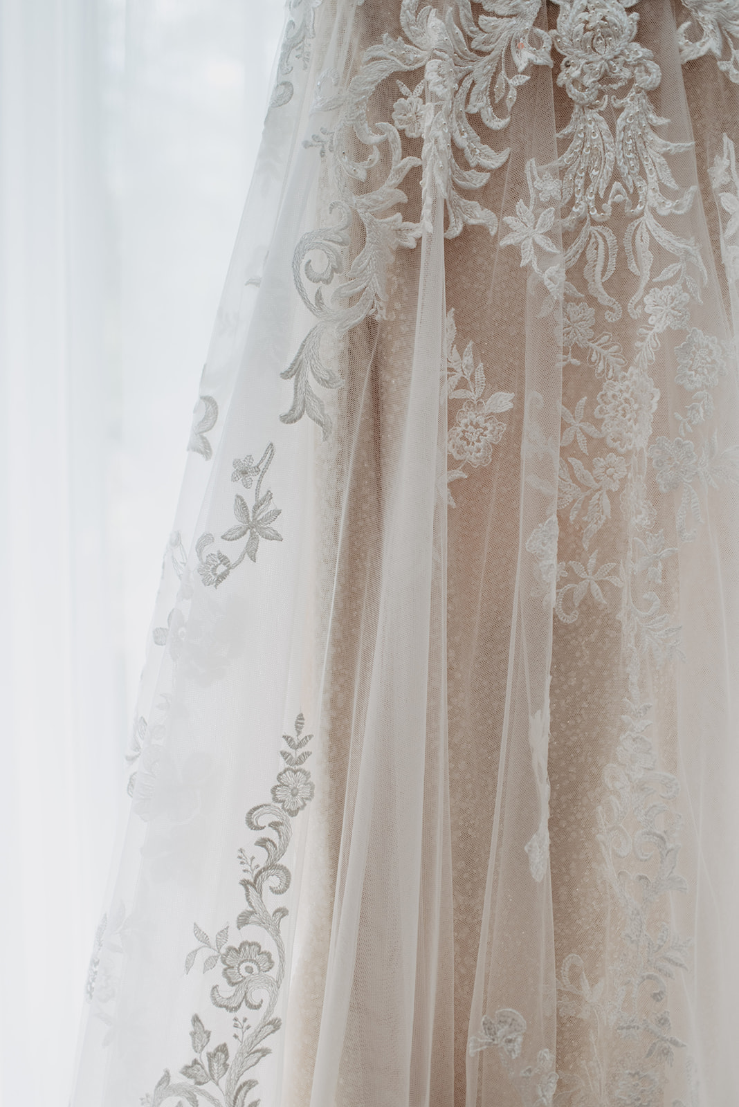 bridal gown with tulle and lace skirt sitting in a window for a detail shot