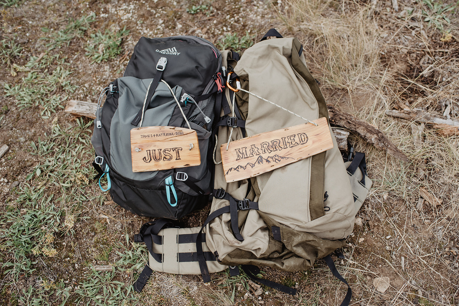 bride and groom back packs with just married signs on them on a hiking trail in the Tetons