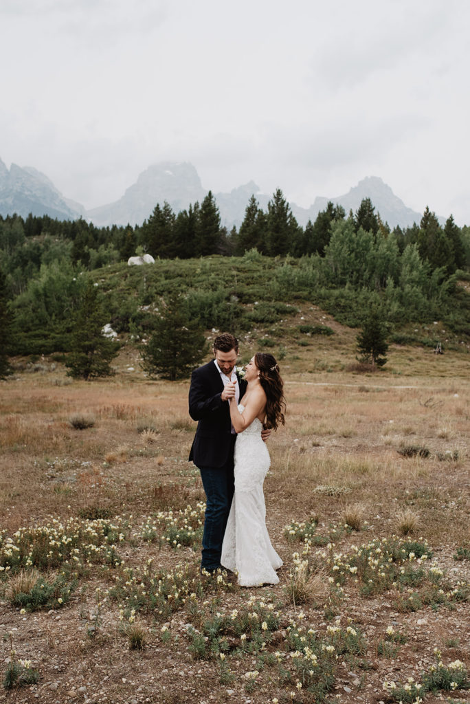 bride and groom dancing in Grand Teton National Park on their wedding day in the fall with the Tetons in the background