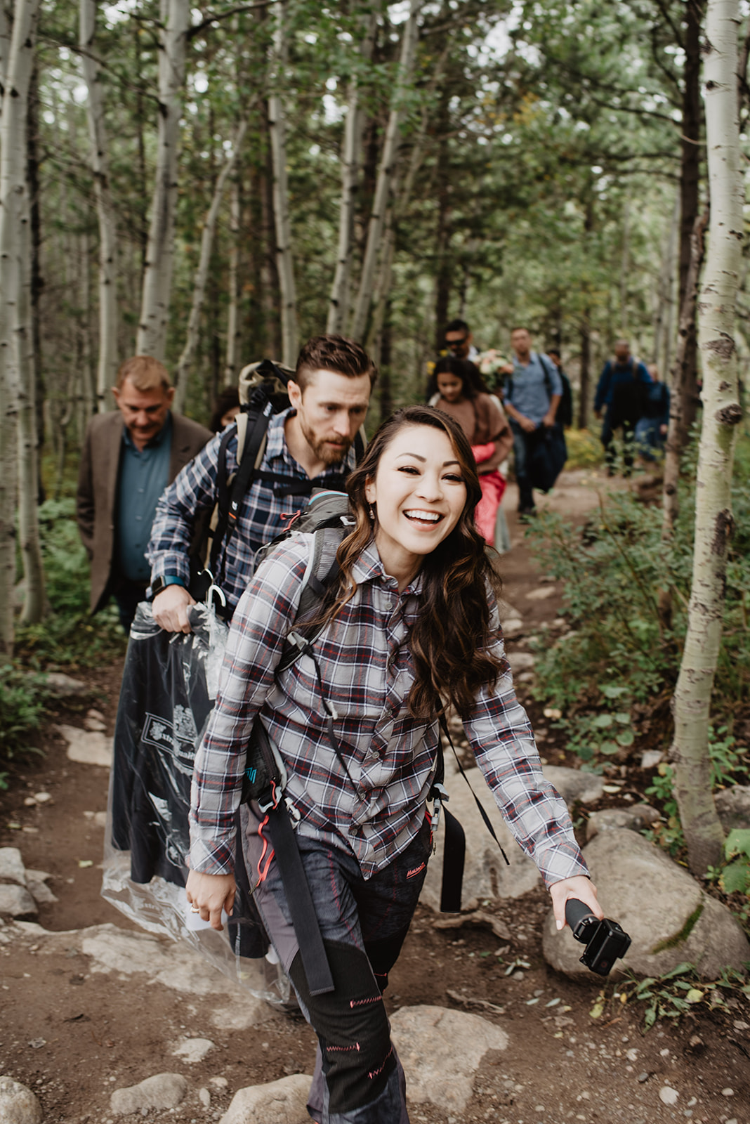 bride and groom hiking in Grand Teton national park to get to their wedding day destination for their adventure wedding