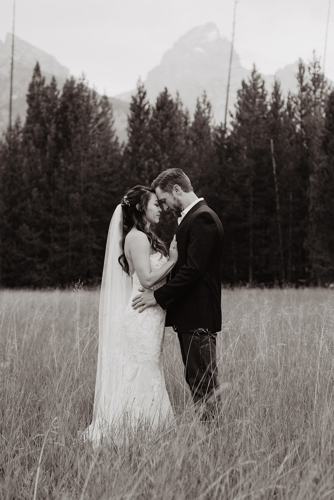 bride and groom embracing in a field in Jackson Hole on their wedding day after they read their private vows to each other