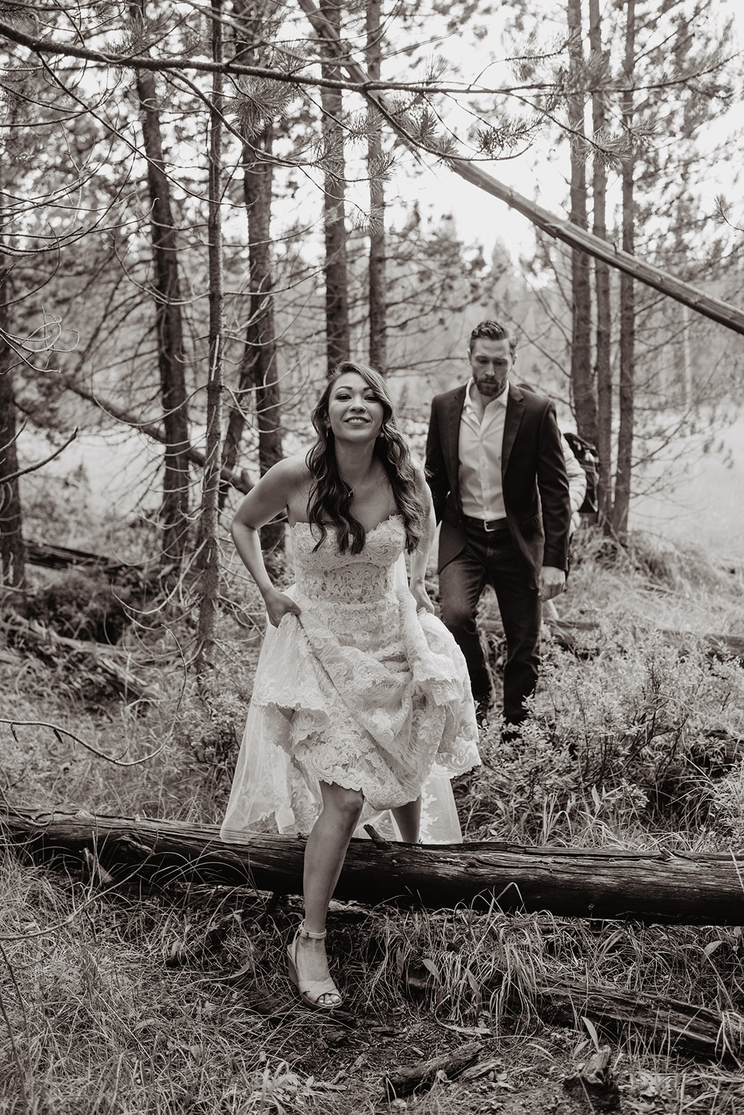 bride and groom hiking in Jackson Hole on their wedding day through the woods