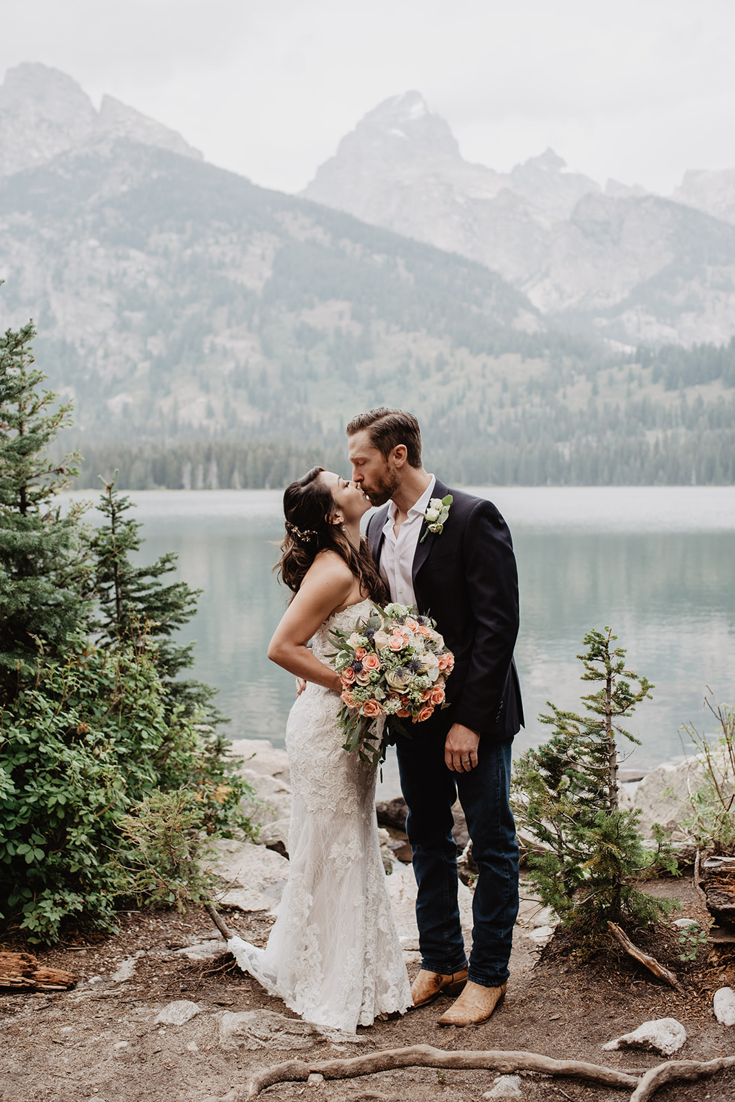 bride and groom standing on some rocks at Taggart lake of their wedding day taken by Grand Tetons Wedding photographers