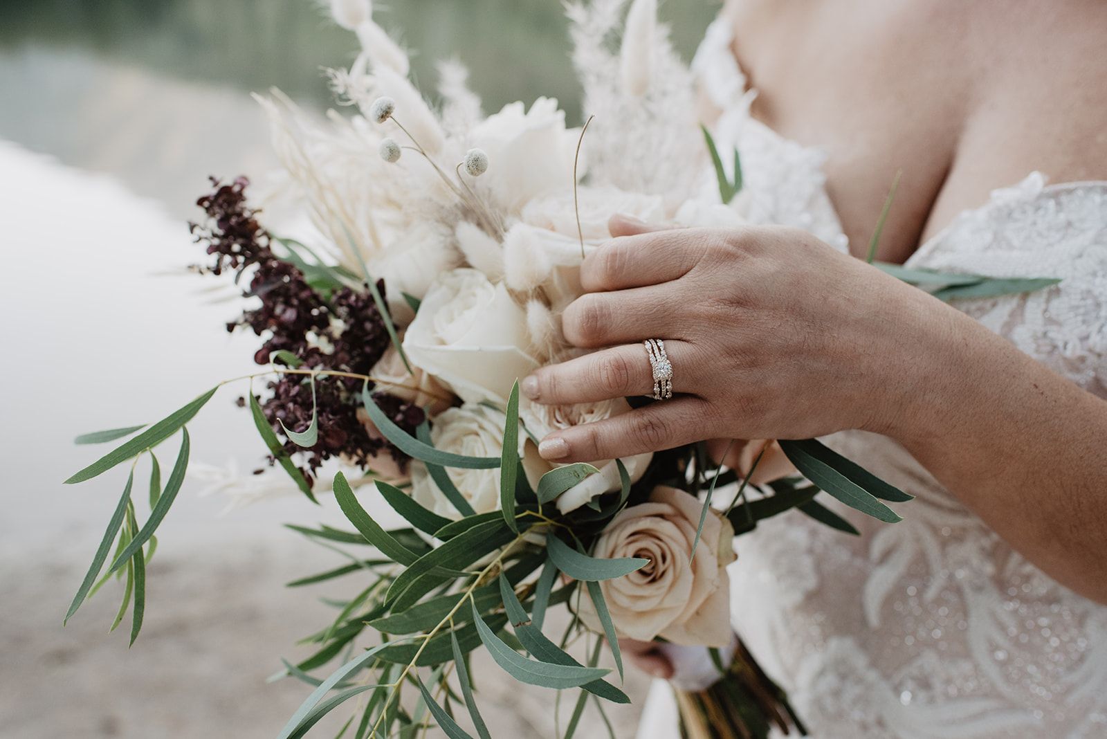 detail shot of bridal bouquet with bride hlding her hand lightly over the florals to show off her wedding ring