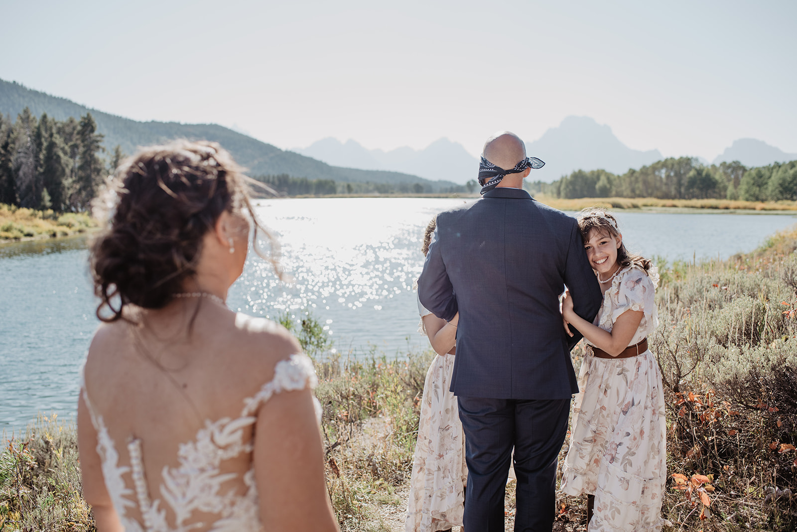 first look from the brides perspective with the groom facing away from the bride at Oxbow Bend in Jackson Hole as the bride walks up behind him for the first look