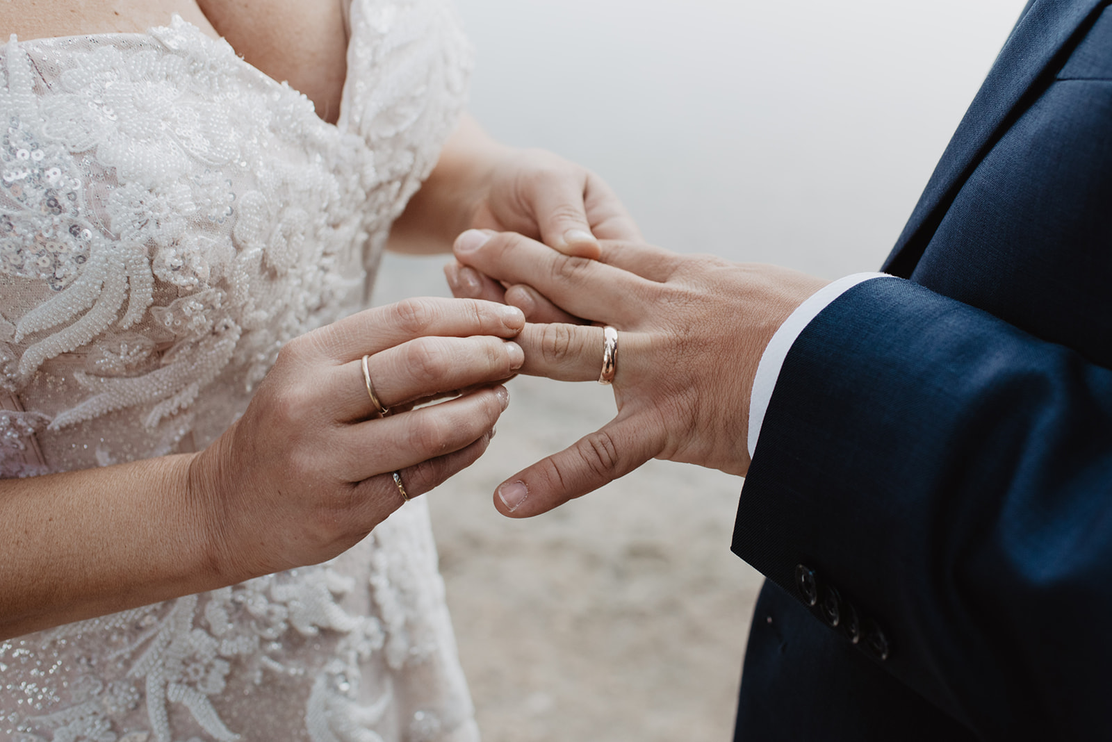 detail shot of bride putting on her grooms rings on their Jackson Hole wedding