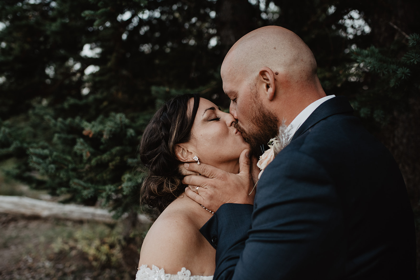 bride and groom kissing during their bridals as they walk through the woods in the Grand Tetons captured by the best Grand Tetons wedding photographer