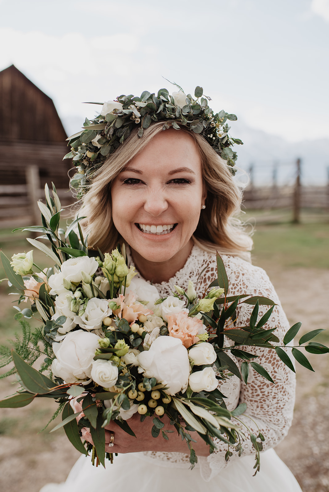 stunning bride smiling at the camer as she holds her wedding bouquet in the Tetons