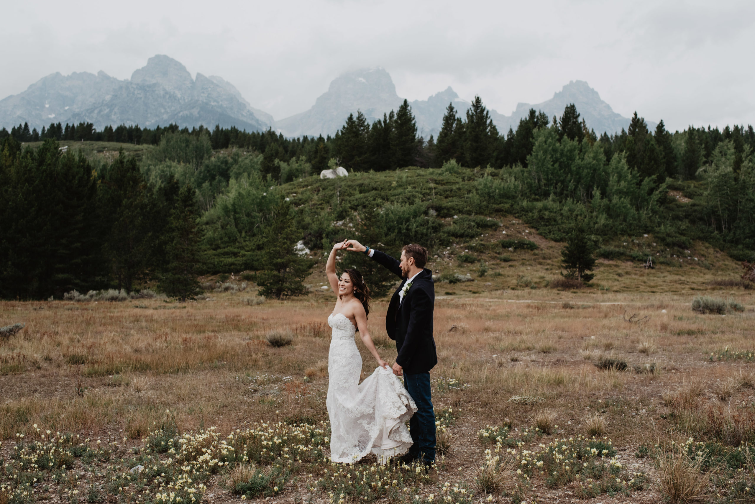 bride and groom dancing together in a meadow in Jackson Hole for their Grand Teton elopement