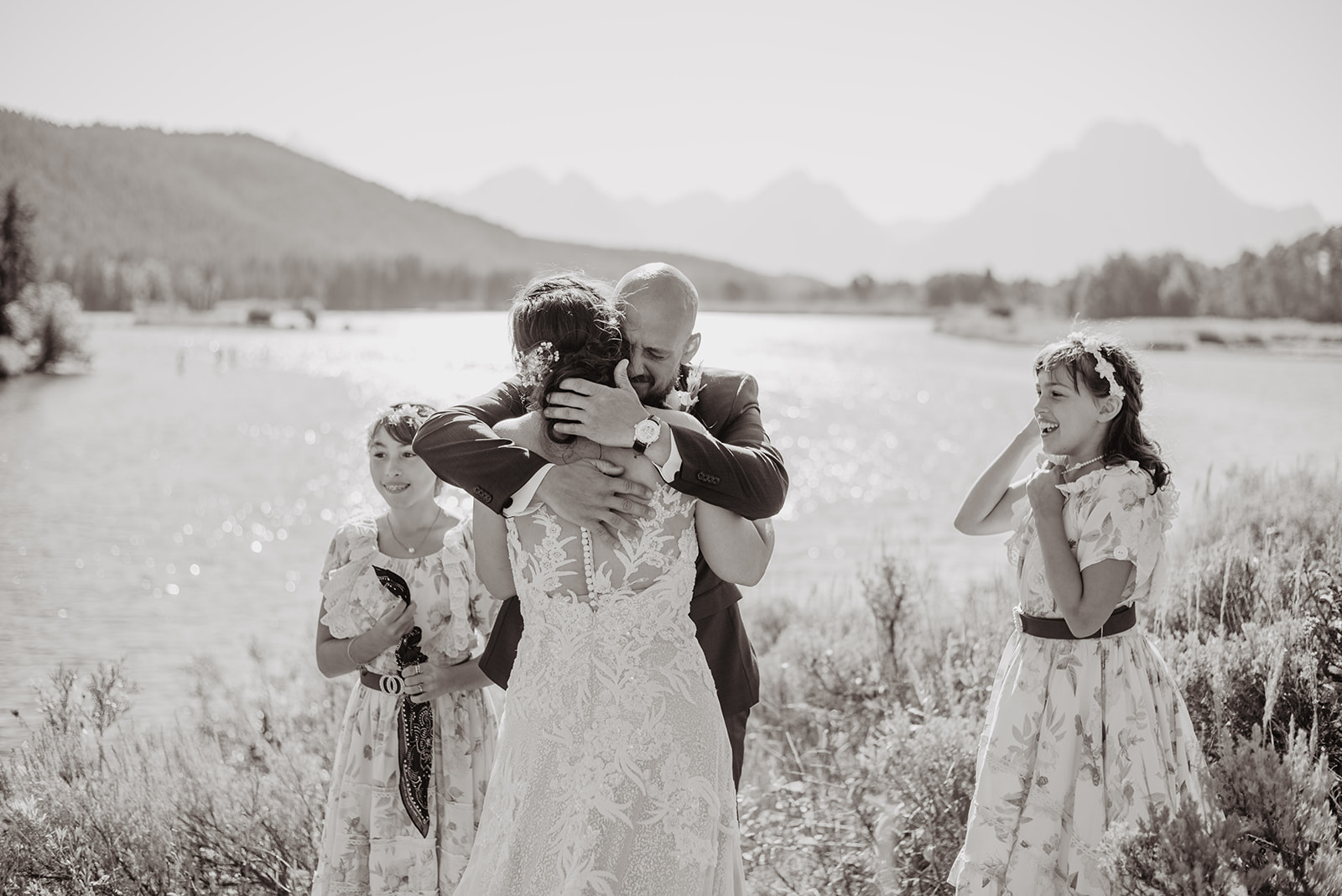 first look in Jackson Hole next to a river with the groom hugging his bride as he cries