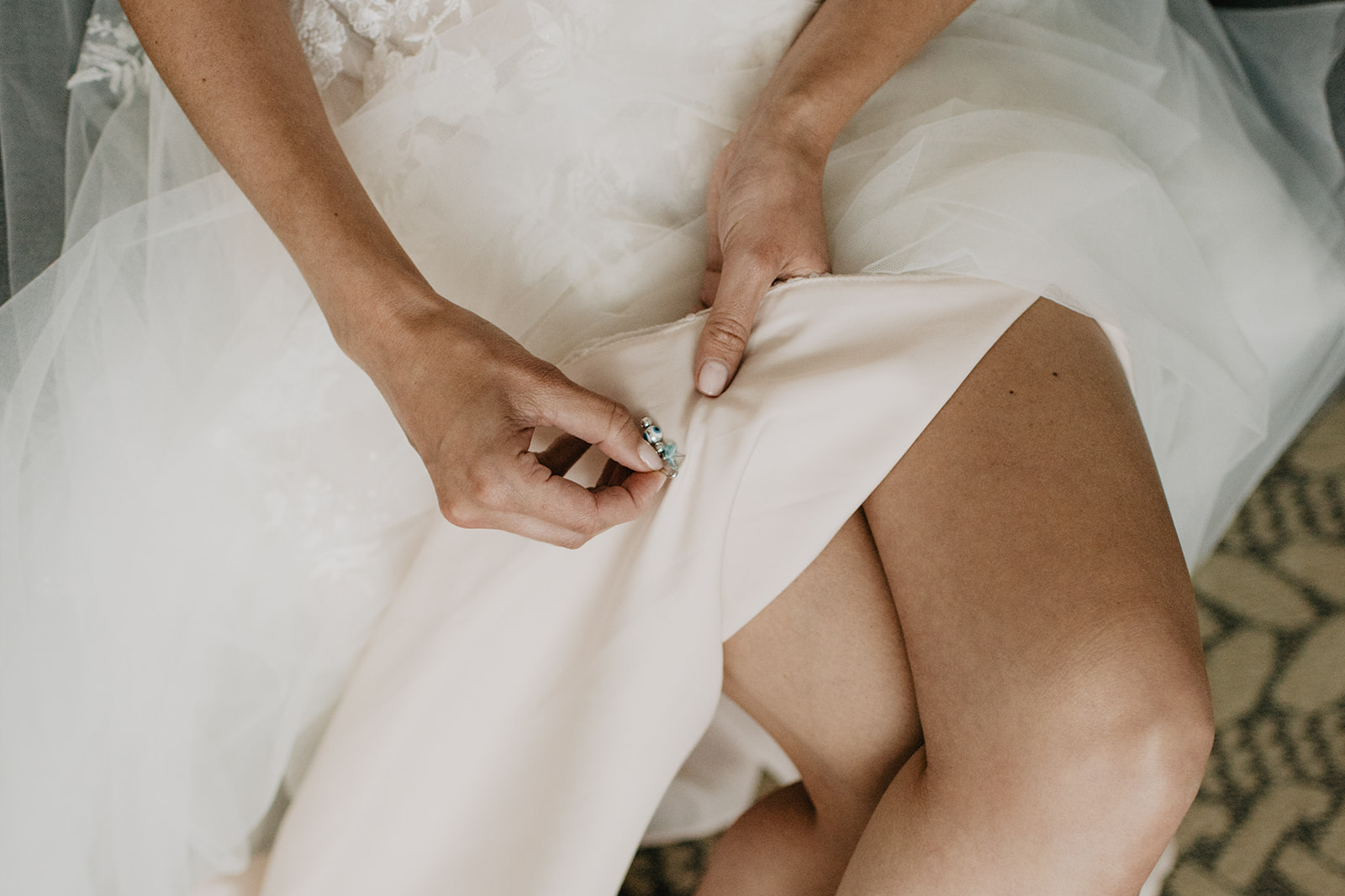 bride touching a blue detail that is on the inside on the wedding dress