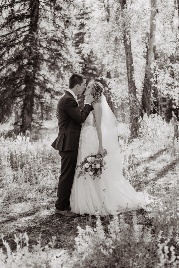 black and white image of bride and groom in the woods of Jackson Hole during their elopement