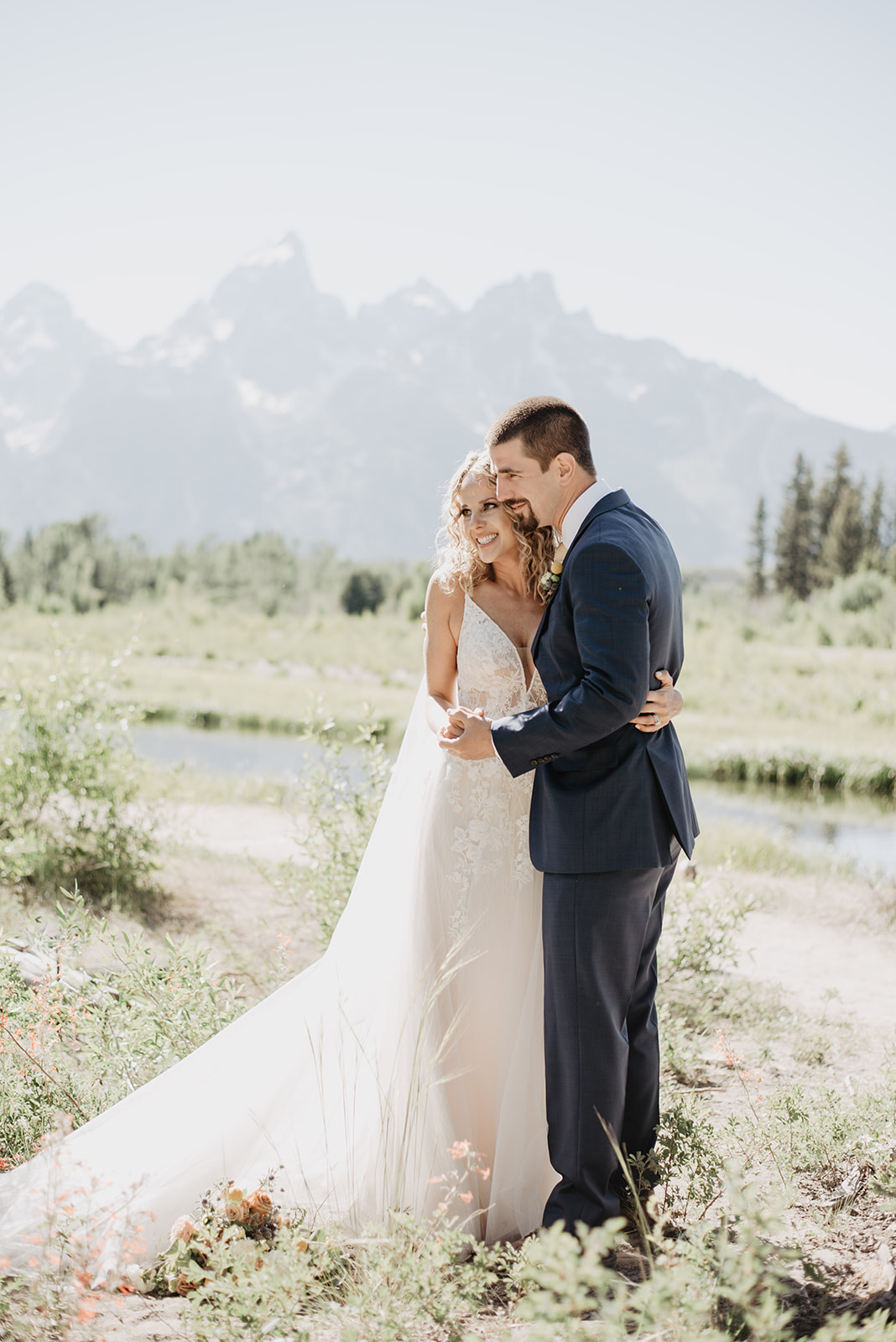 bridals in Jackson Hole for an elopement party with the bride and groom embracing each other and smiling as the Grand Tetons stand behind them