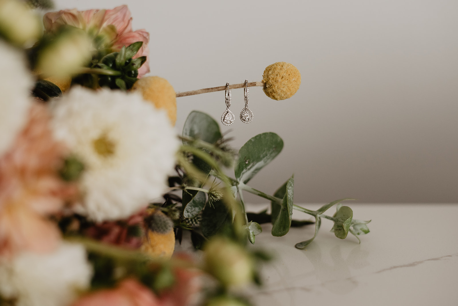 wedding details of brides florals and earrings for a Jackson Hole wedding in the Spring