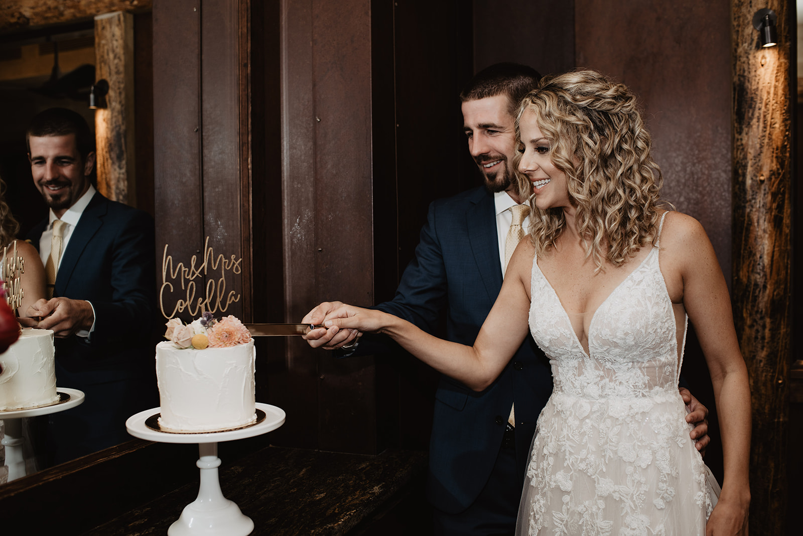 bride and groom both holding a knife as they cut their cake together on their elopement in a Jackson Hole elopement photographer