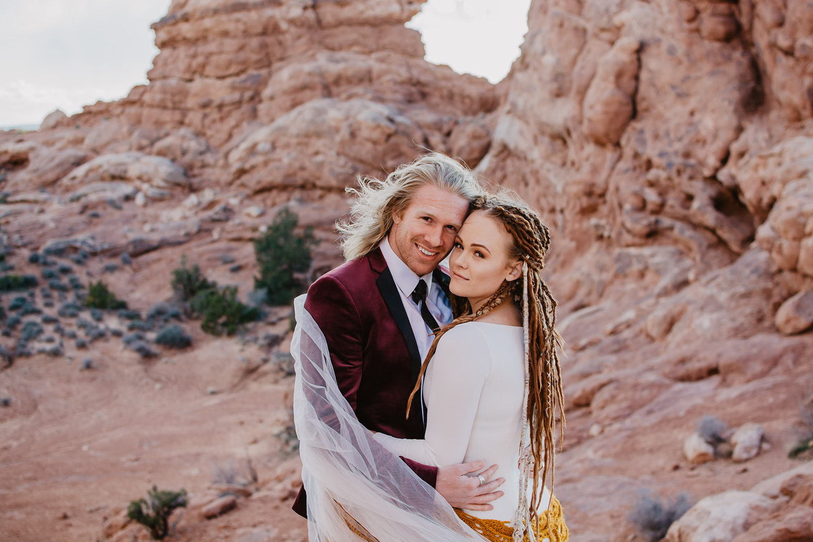 Arches National Park elopement with bride and groom embracing each other amongst the red rocks for their adventure elopement