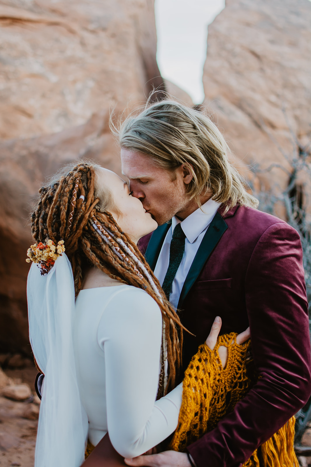 bride and groom passionately kissing one another in the desert of Arches National park for their elopement