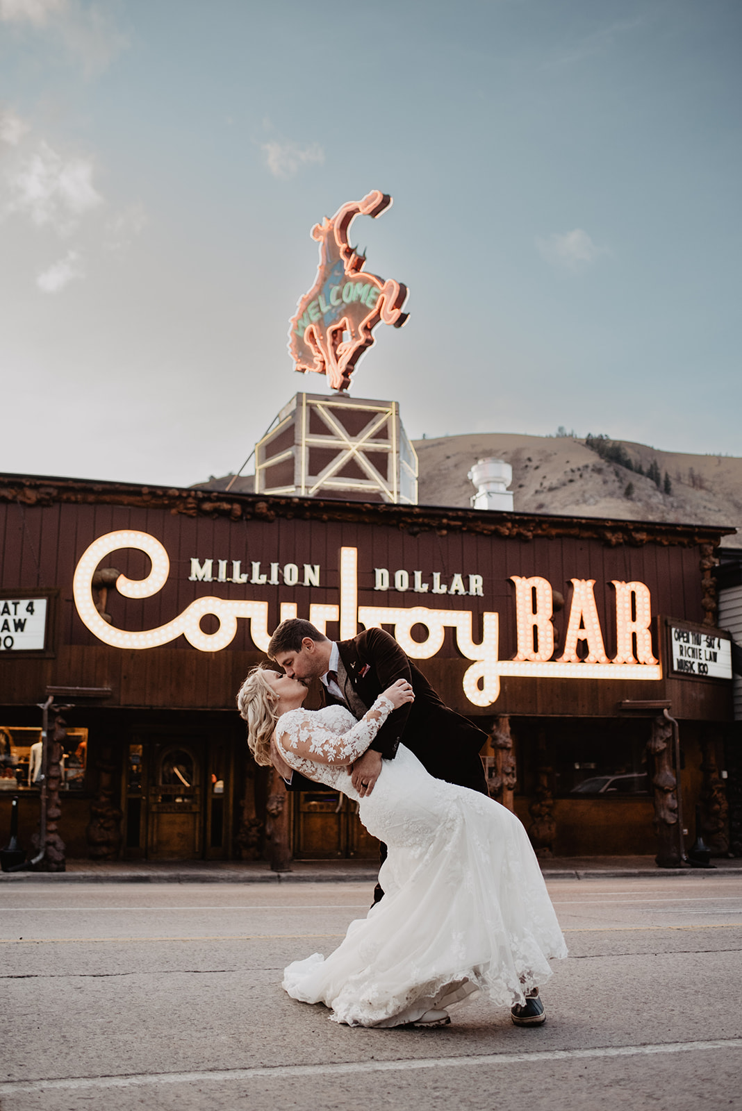 groom dipping his bride back as they dance in the road at the Cowboy Bar in Jackson Hole
