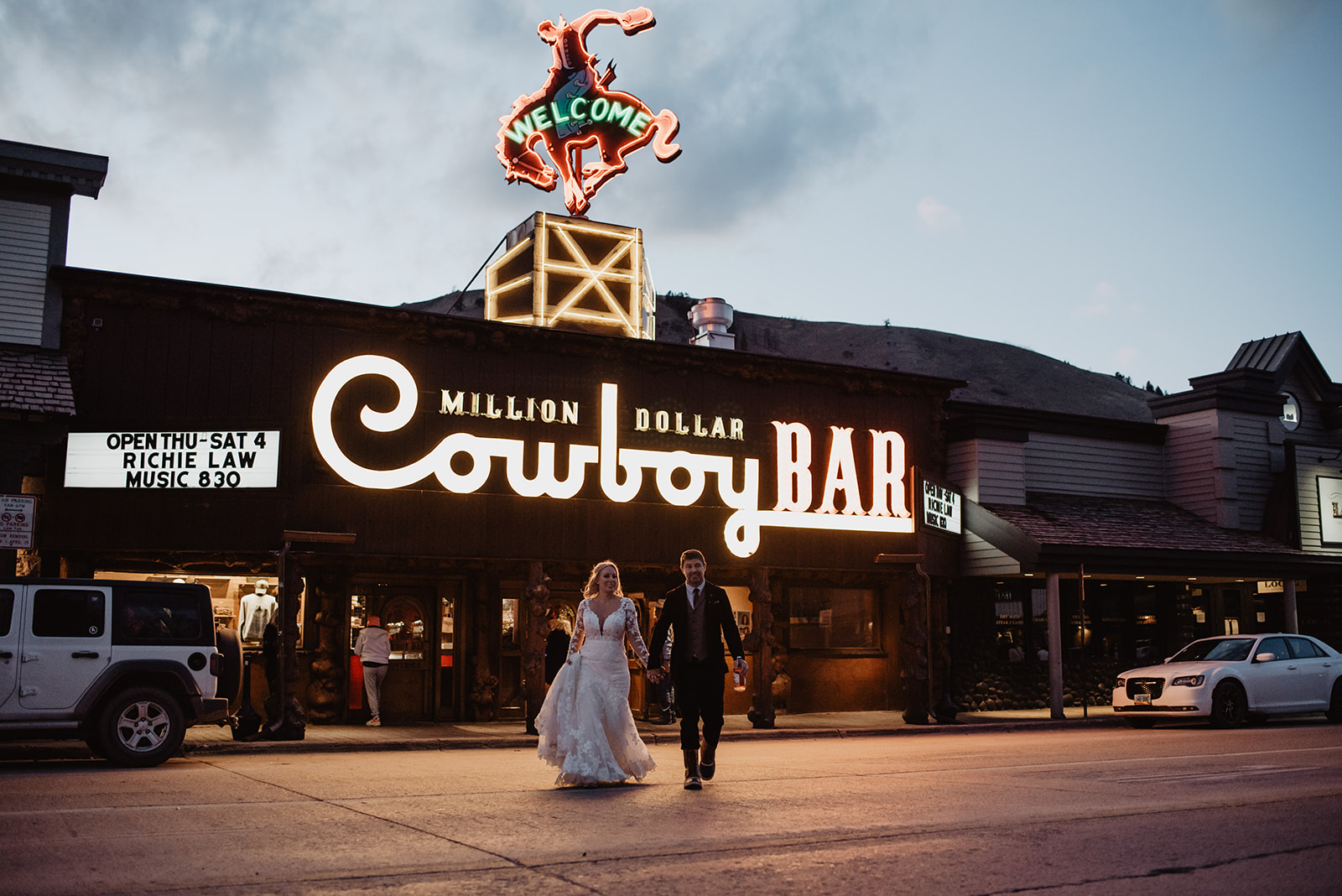 bride and groom walking out of the Cowboy Bar in Jackson Hole after celebrating their wedding with drinks