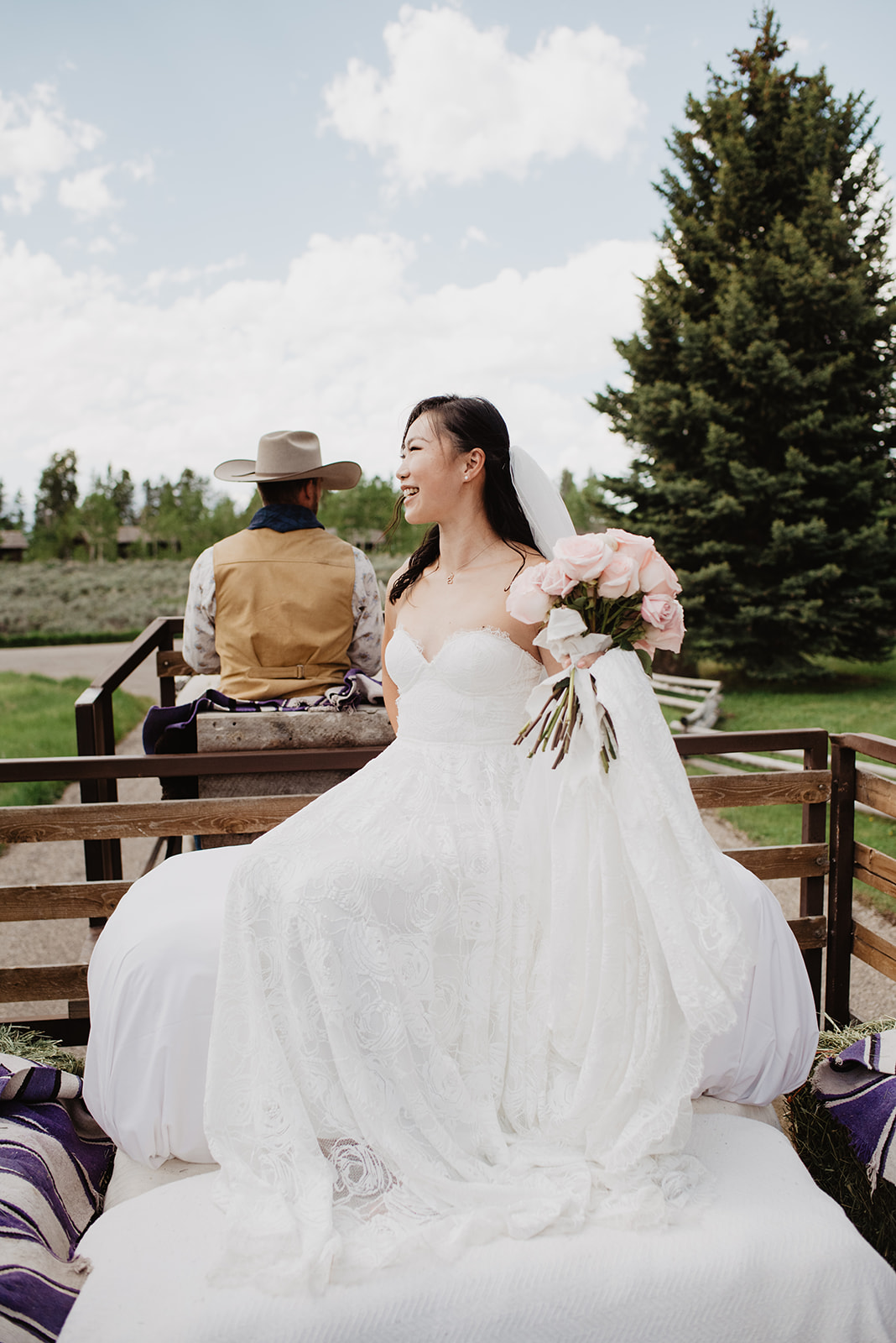 bride riding in a horse drawn wagon into her wedding ceremony in Jackson Hole