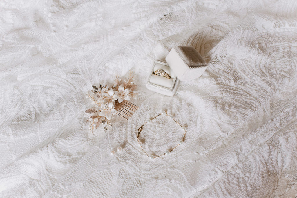 bridal jewelry laid out on a piece of lace in a bridal suite captured by jackson hole photographers