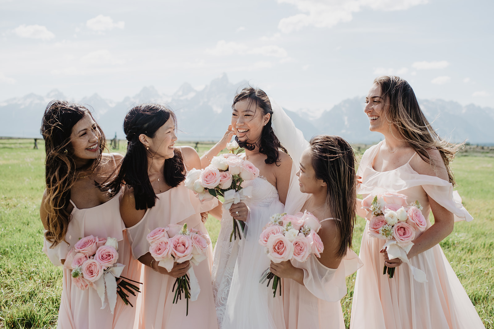 bride with her bridesmaids for their outdoor wedding in the Tetons posing together with their bridal bouquets