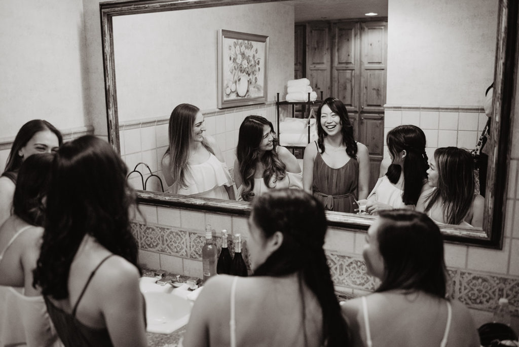 bride in the bathroom getting ready with her bridesmaids for her wedding day with Jackson Hole wedding photographer 