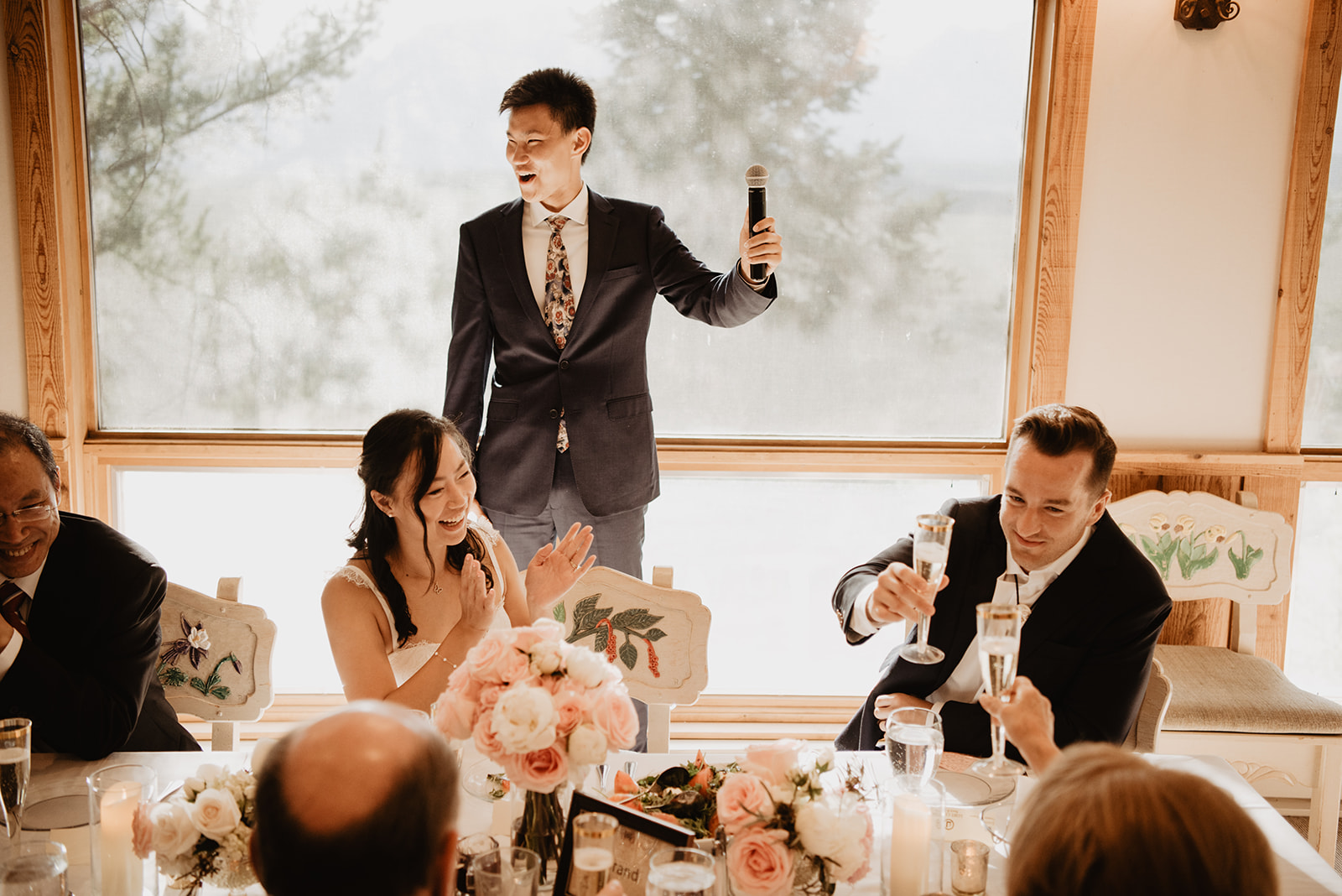 intimate dinner party for a Jackson Hole wedding with man standning and giving a toast to the bride and groom