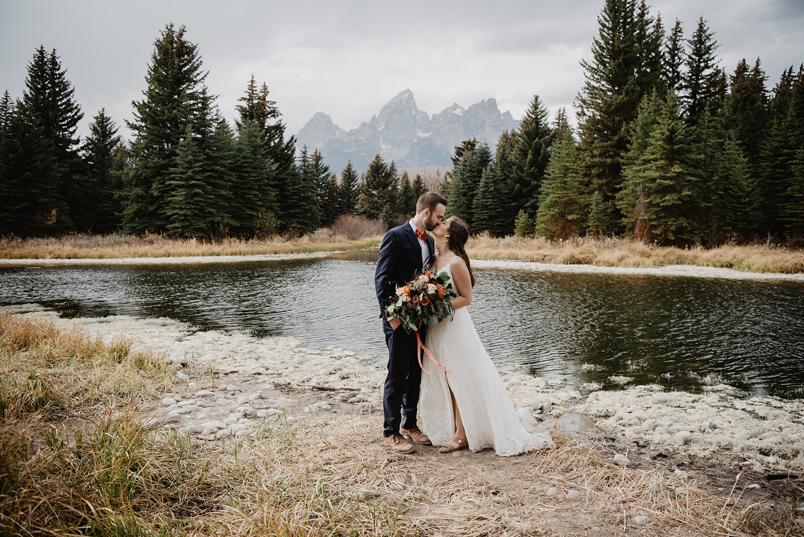 bride and groom in Jackson Hole dancing together next to a river in Jackson Hole