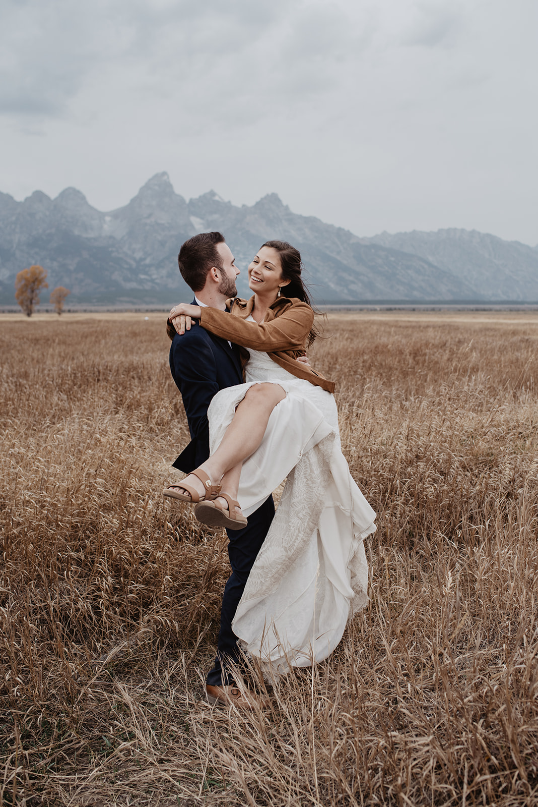 groom carrying his bride in his arms in the Grand Tetons