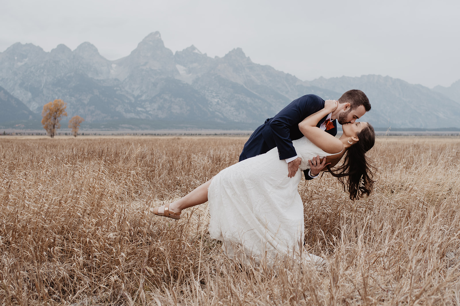 groom dipping his bride in a golden field in Jackson Hole for their first dance