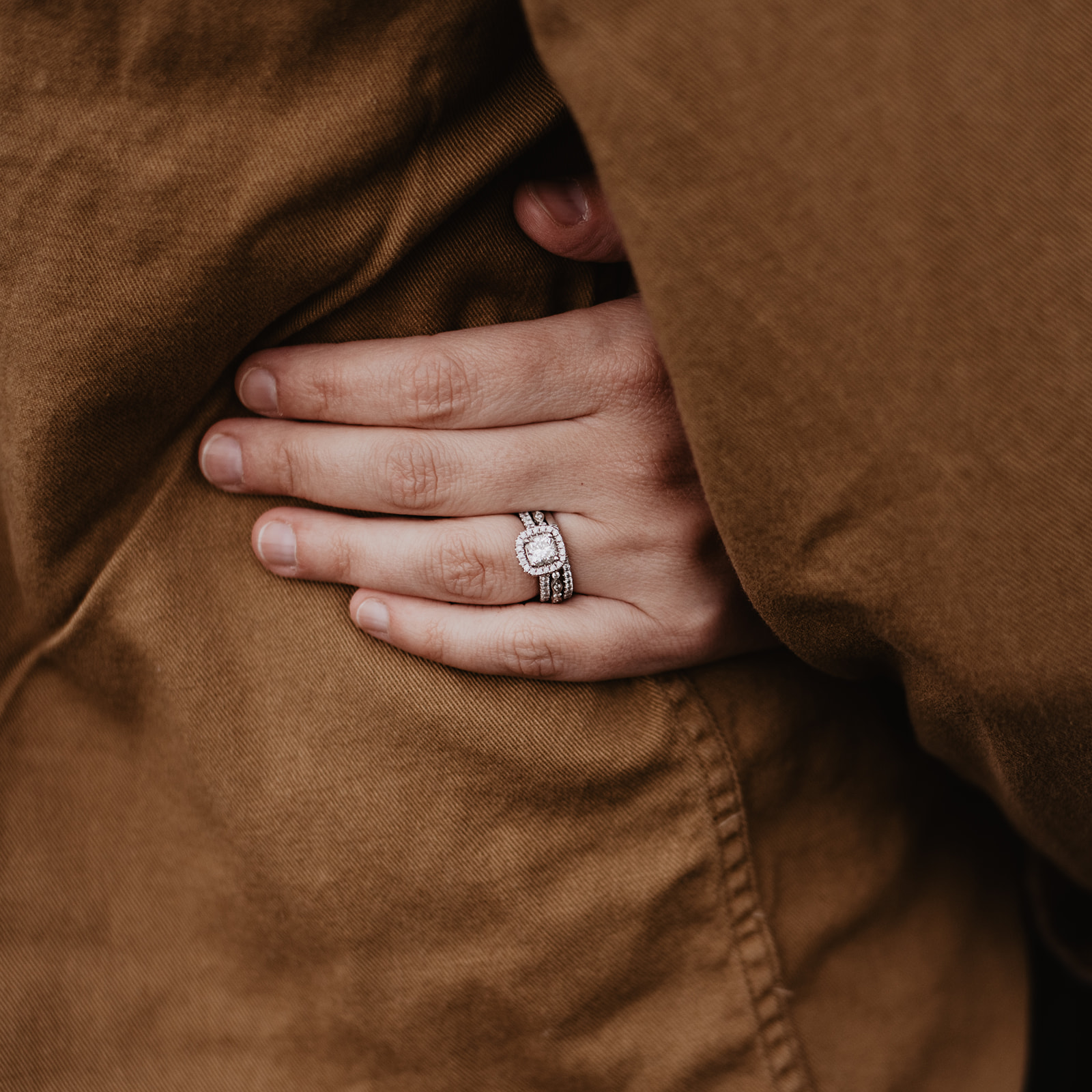 Rainy Day Photos In The Tetons wedding ring detail shot on top of a brown coat