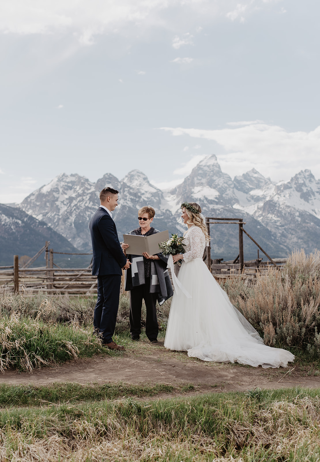 bride and groom getting married by the wedding officiant in the Tetons in the spring