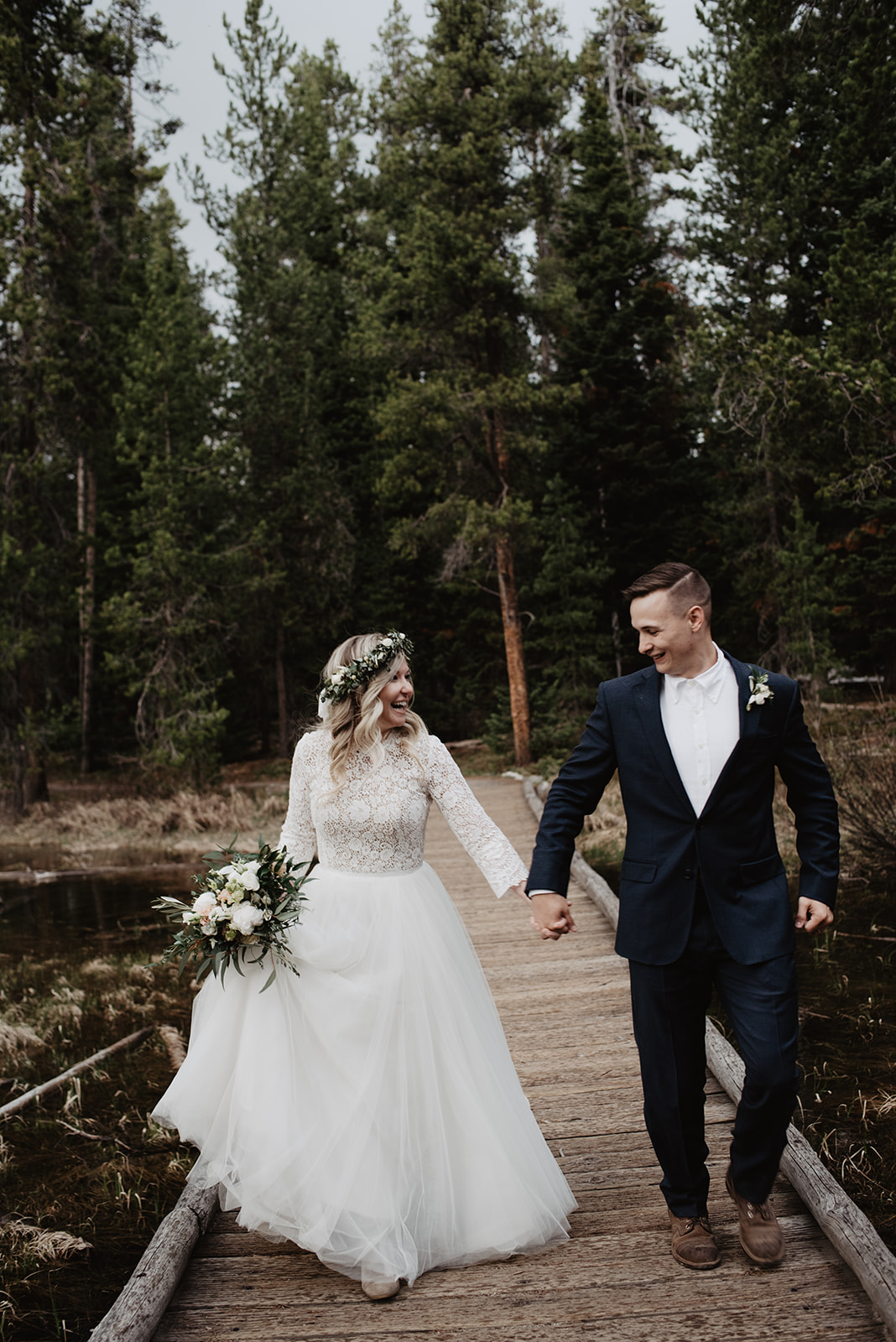 bride and groom running down the dock at String Lake captured by best Grand Teton Wedding Photographer