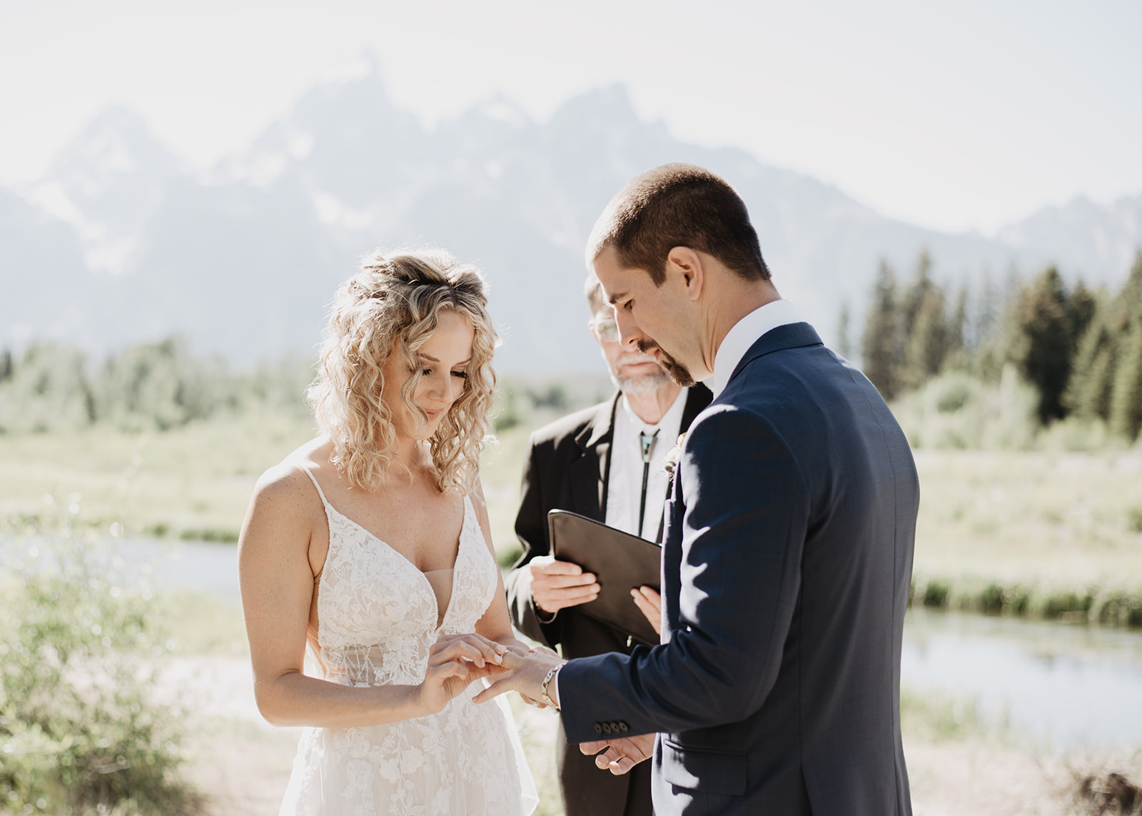 ring exchange during a wedding ceremony at Schwabacher Landing in the Grand Tetons