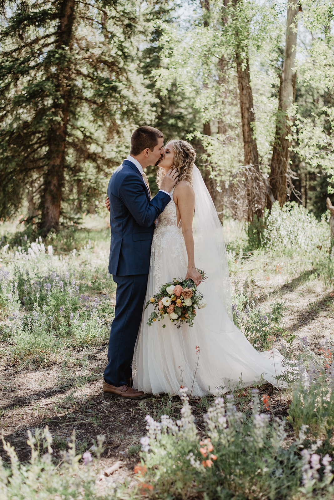 bride and groom standing together in the woods of the Grand Tetons and embracing each other