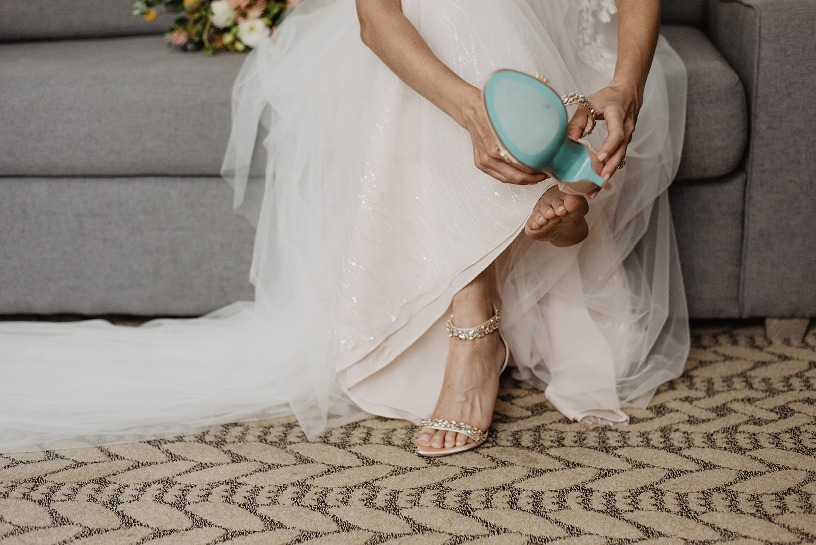 detail shot of bride putting on her wedding heels with blue bottoms at Snow King Resort